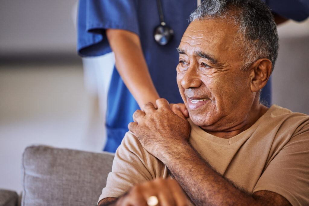 Nurse or doctor give man support during recovery or loss. Caregiver holding hand of her sad senior patient and showing kindness 