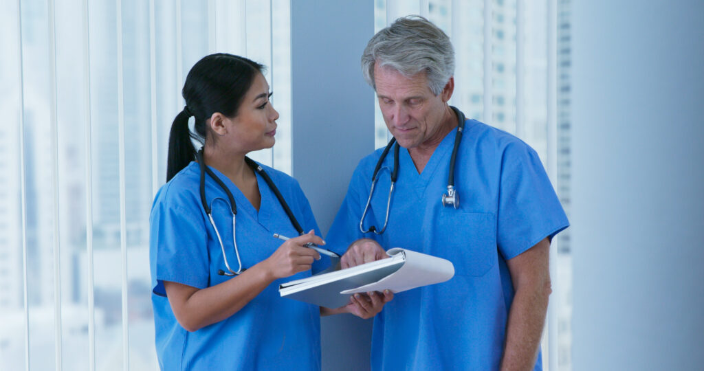 Japanese woman doctor and Caucasian male nurse going over paperwork in hospital