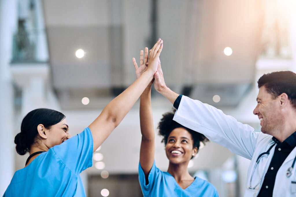 Shot of a diverse team of doctors giving each other a high five in a hospital.